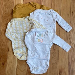 Four 0-3 month white and yellow Cloud Island and Old Navy bodysuits